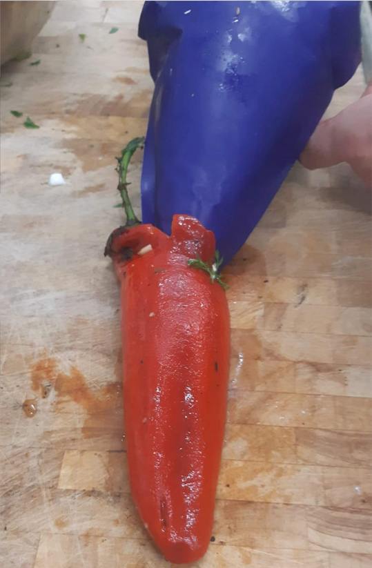 פלפל שושקה קלוי במילוי לבנה עגבניות מיובשות מוגש עם סלט ירוקים ופיצוחים